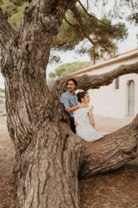 Photographie d'un couple assis sur un arbre.