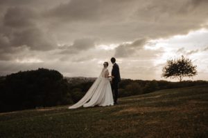 Photographie de jeunes mariés regardant vers l'horizon.