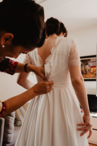 Photographie de la future mariée en train de s'habiller.