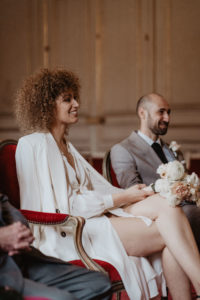 Photographie d'un couple assis pendant sa cérémonie de mariage.