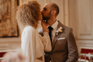 Photographie d'un couple s'embrassant pendant sa cérémonie de mariage.