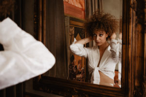Photographie d'une femme se coiffant devant le miroir.